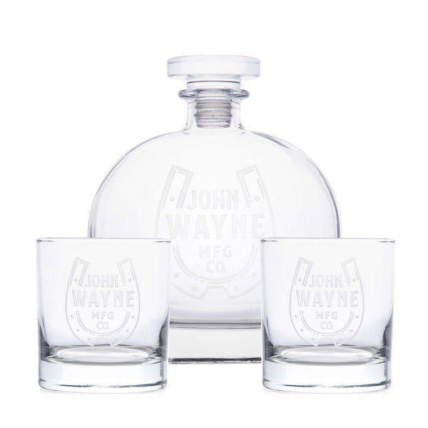 decanter and two whiskey glasses with john wayne MFG Co. and horse shoe design