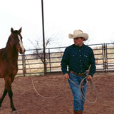 man guiding horse wearing cobalt blue button up long sleeve with john wayne silhouette on left chest pocket