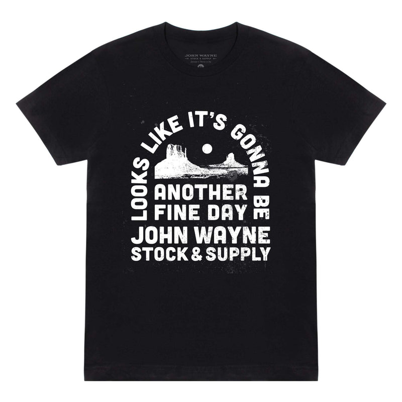 front of black t-shirt with "looks like it's gonna be another fine day john wayne stock & supply" and desert scene on it