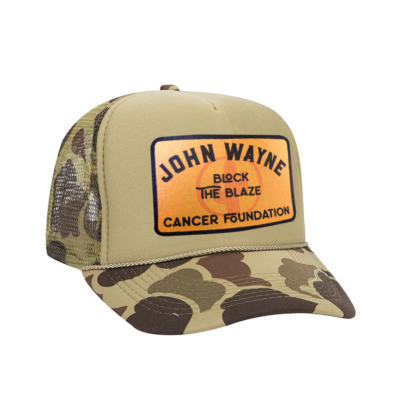 front of camo trucker hat with "john wayne block the blaze cancer foundation" in orange patch design 