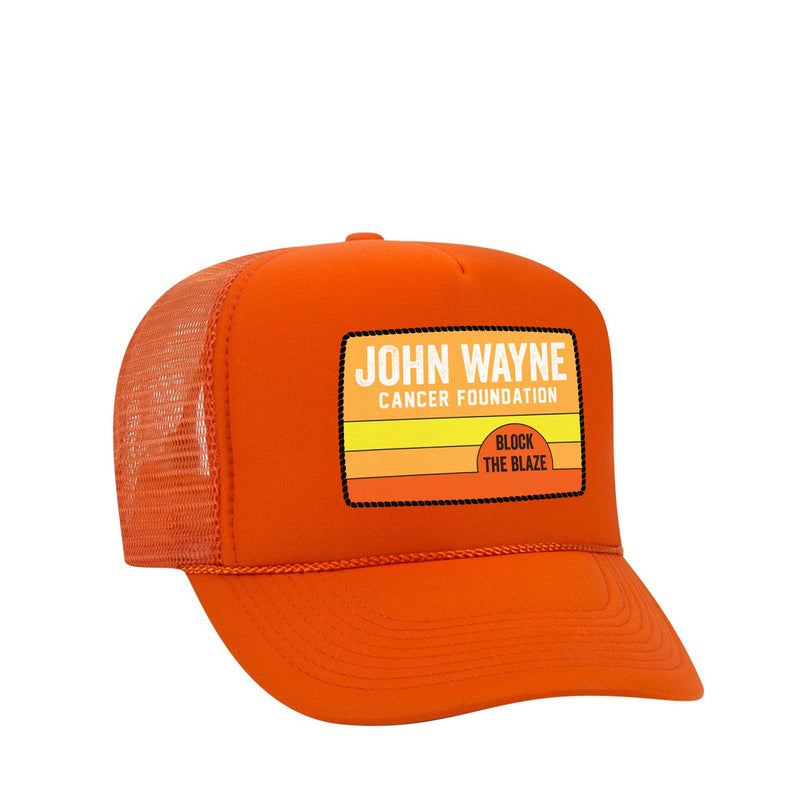 front of trucker hat with "john wayne cancer foundation block the blaze" with sunlike background 