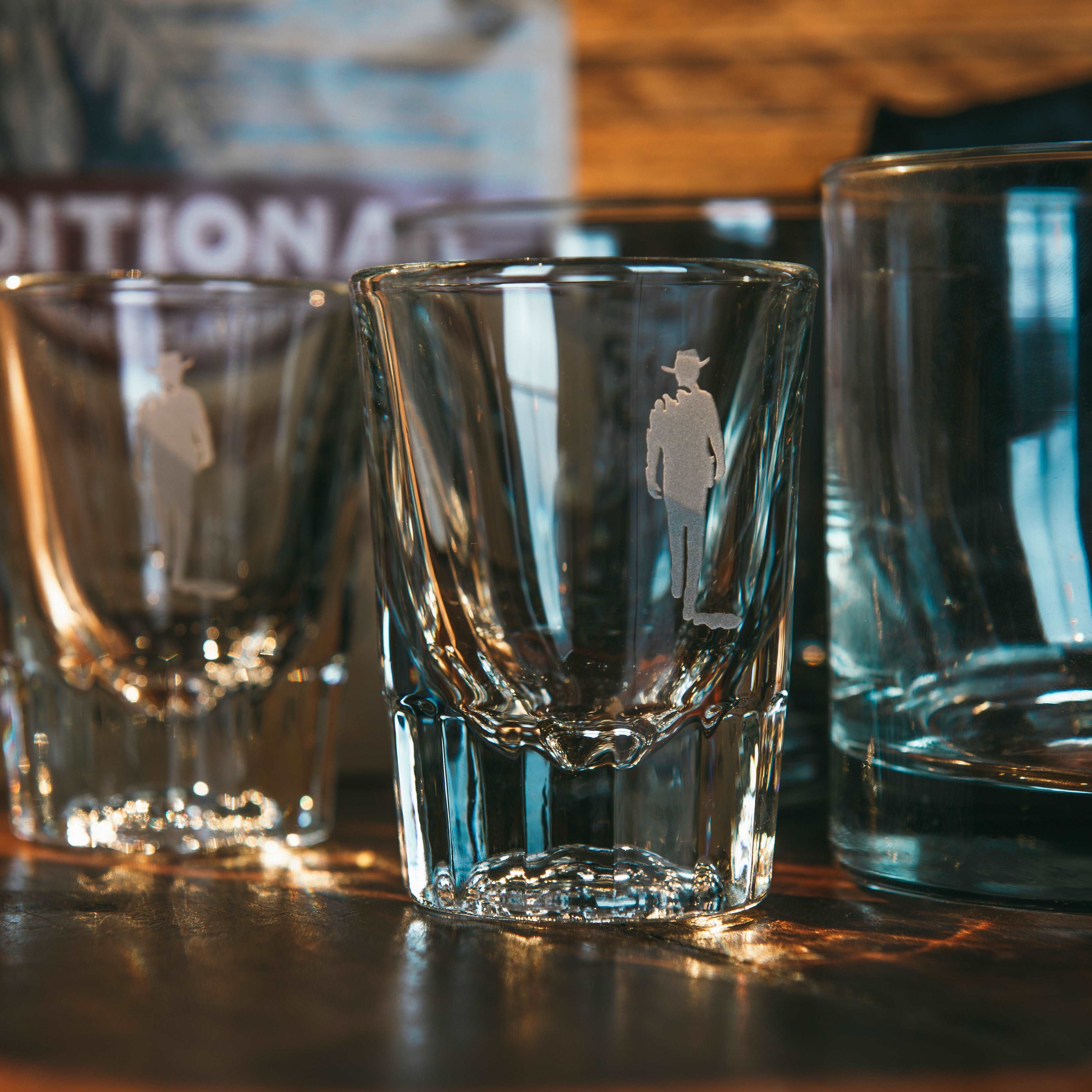  two shot glasses with sandblasted john wayne silhouette on counter