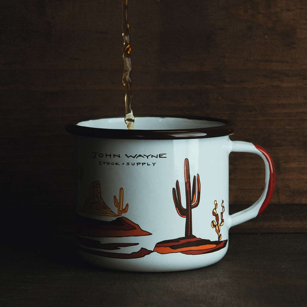 dark liquid pouring into mug with monument valley cactus scenery 