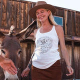 woman standing by donkey with tank on that has JW and flower like design around it