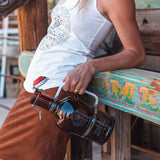 chest down of woman leaning on wood with john wayne growler in one hand