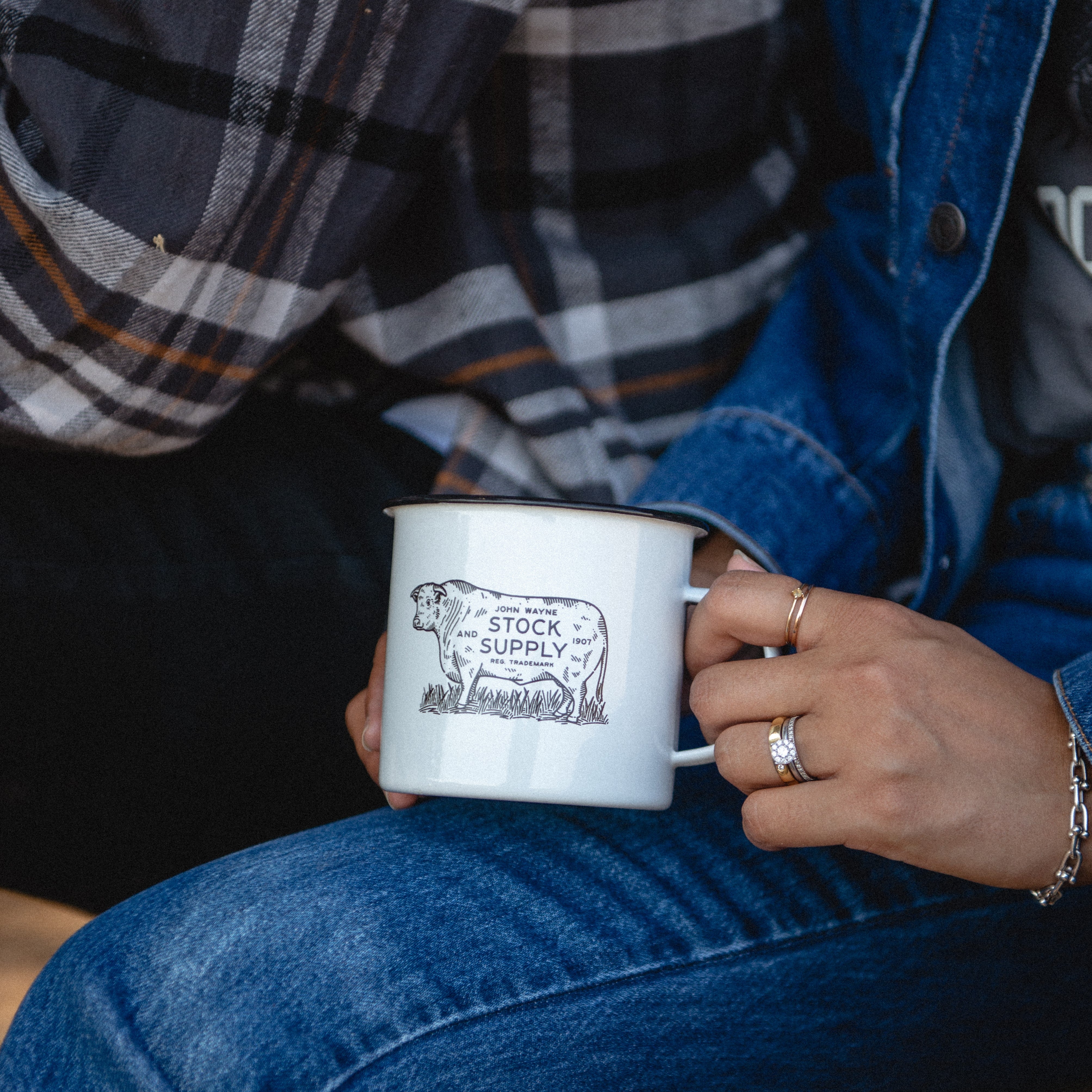 woman's hand holding mug with cattle that has 