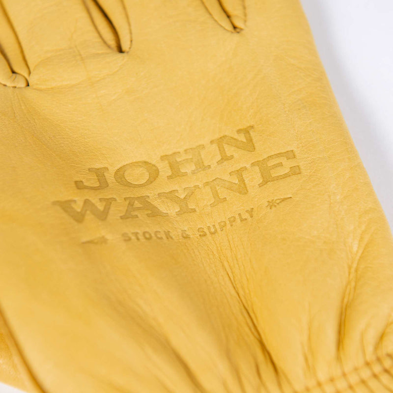 close up of john wayne stock and supply on work gloves