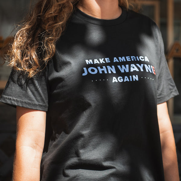 close up of woman wearing black t-shirt with "make america john wayne again"