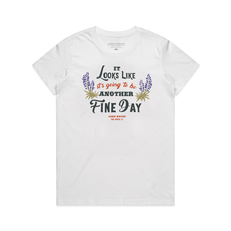 front of white women's t-shirt with "it looks like it's going to be another fine day" and two plants on either side of it